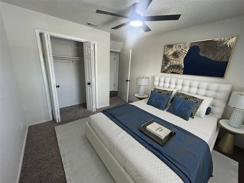 4639 Williams Road, #219, Benbrook, TX 76116 Carpeted bedroom with a textured ceiling, a closet, and a ceiling fan