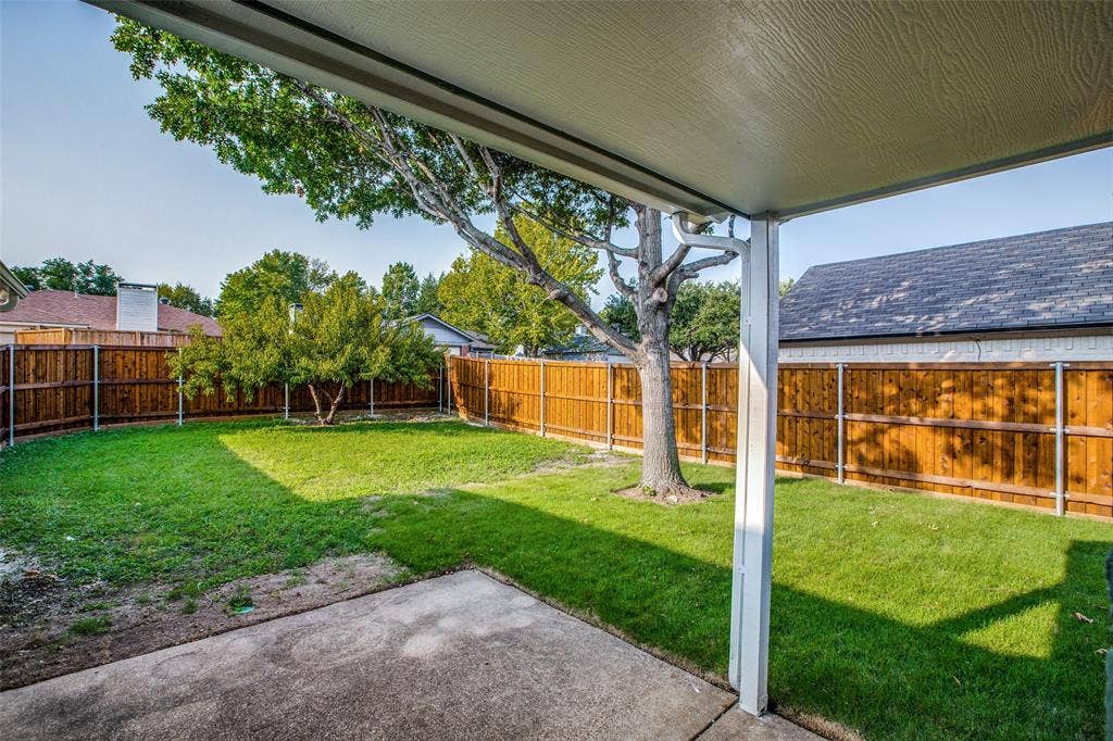 8341 Edgewater Drive, Frisco, TX 75034 Covered patio with a concrete surface, manicured lawn, full privacy fencing, and mature trees