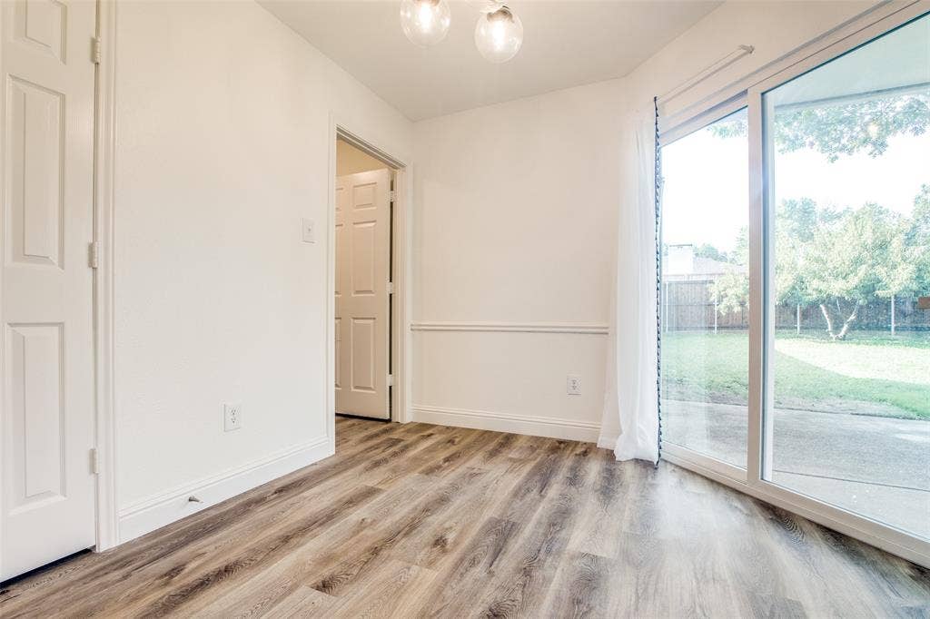 8341 Edgewater Drive, Frisco, TX 75034 Wood-finish flooring, white paneled doors, chair rail molding, and sliding glass door