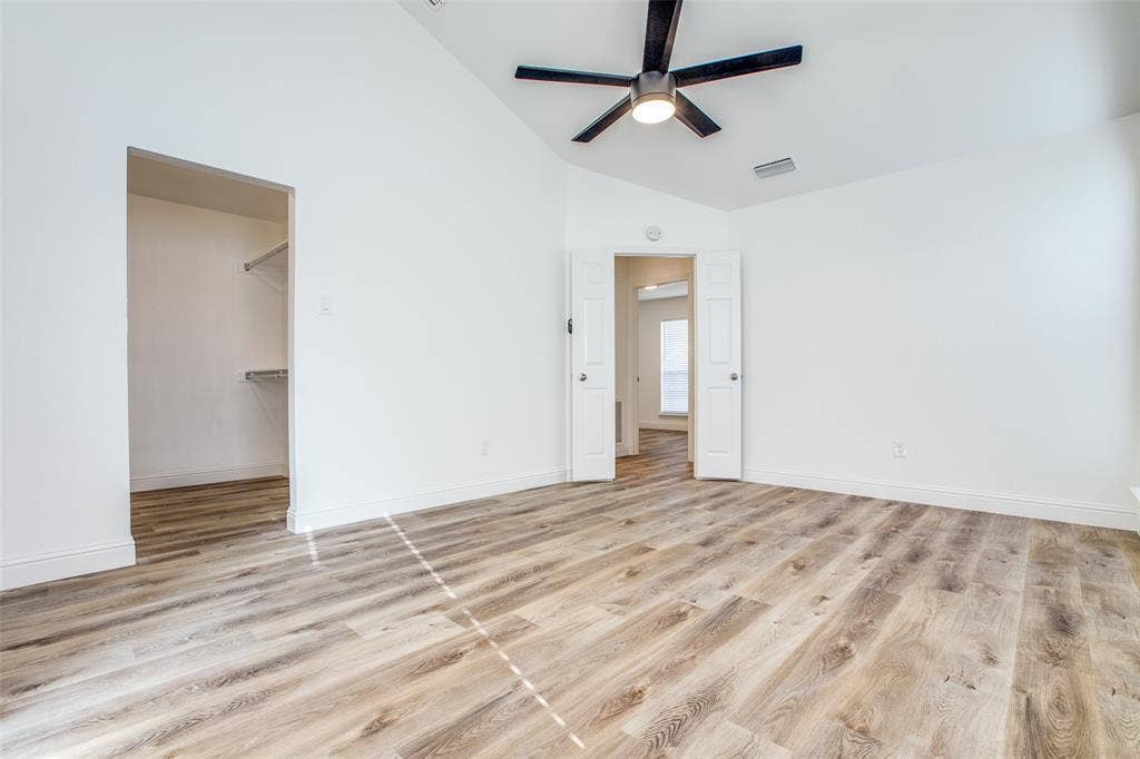 8341 Edgewater Drive, Frisco, TX 75034 Vaulted ceiling, wood-finish flooring, ceiling fan with integrated lighting, double doors, and a walk-in closet with shelving