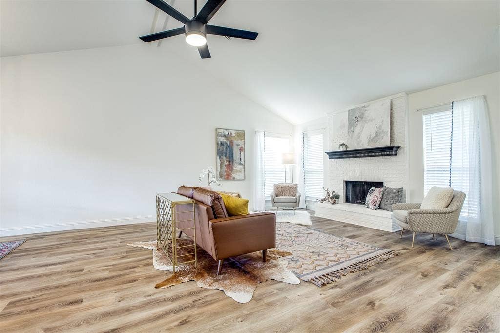 8341 Edgewater Drive, Frisco, TX 75034 Vaulted ceiling, wood-finish flooring, brick fireplace with mantel, ceiling fan, and multiple windows