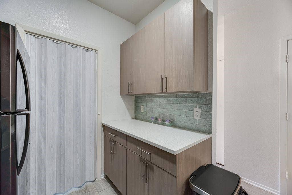 3801 14th Street, #1905, Plano, TX 75074 Built-in cabinetry with ample storage, light-colored countertops, and a modern subway tile backsplash