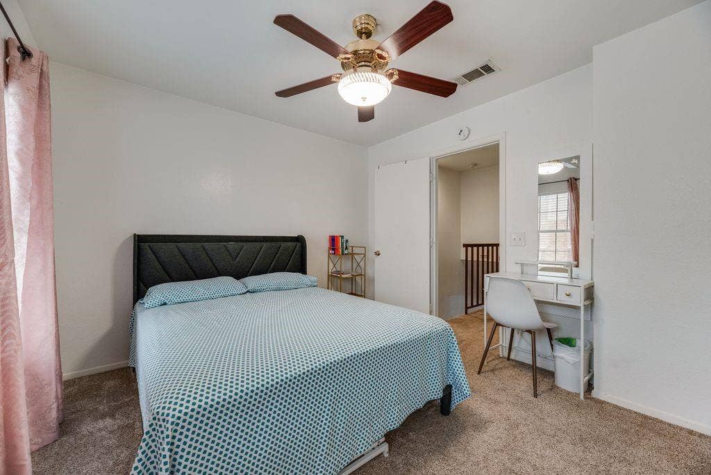 3801 14th Street, #1905, Plano, TX 75074 Textured headboard, ceiling fan with integrated lighting, carpeted flooring, and a mirrored vanity desk