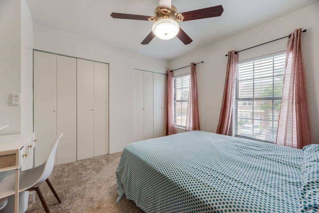 3801 14th Street, #1905, Plano, TX 75074 Carpeted room featuring dual windows with blinds, bi-fold closet doors, and a ceiling fan with integrated lighting