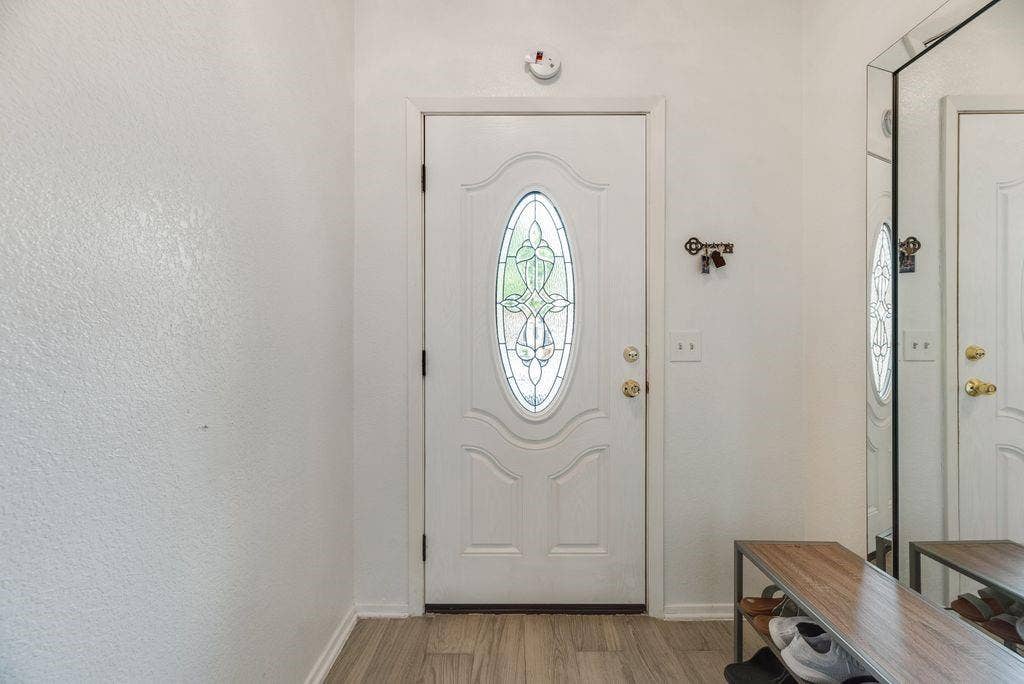 3801 14th Street, #1905, Plano, TX 75074 Entry door with decorative oval glass insert, wood-finish flooring, and white trim