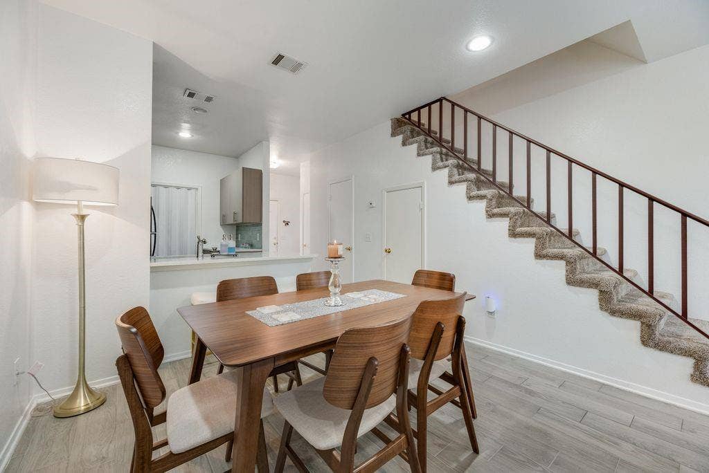 3801 14th Street, #1905, Plano, TX 75074 Wood-finish flooring throughout, with a carpeted staircase featuring a metal railing