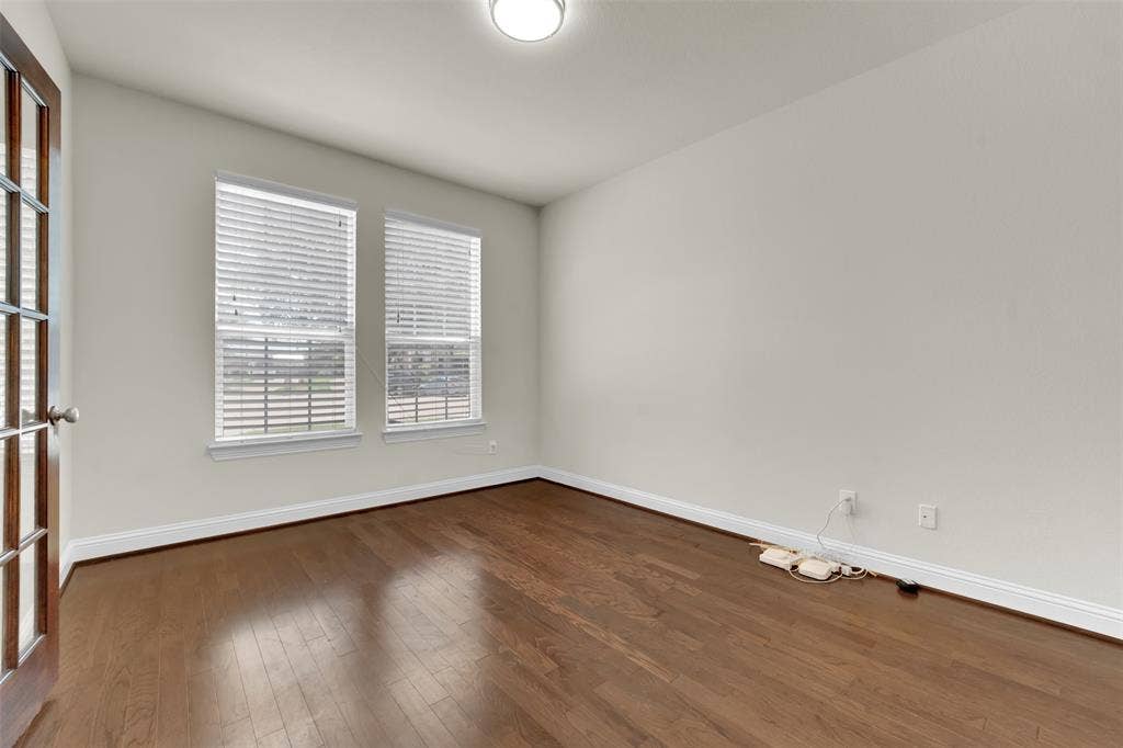 6811 Shady View Court, Sachse, TX 75048 Wood-finish flooring, two windows with blinds, and a paneled door