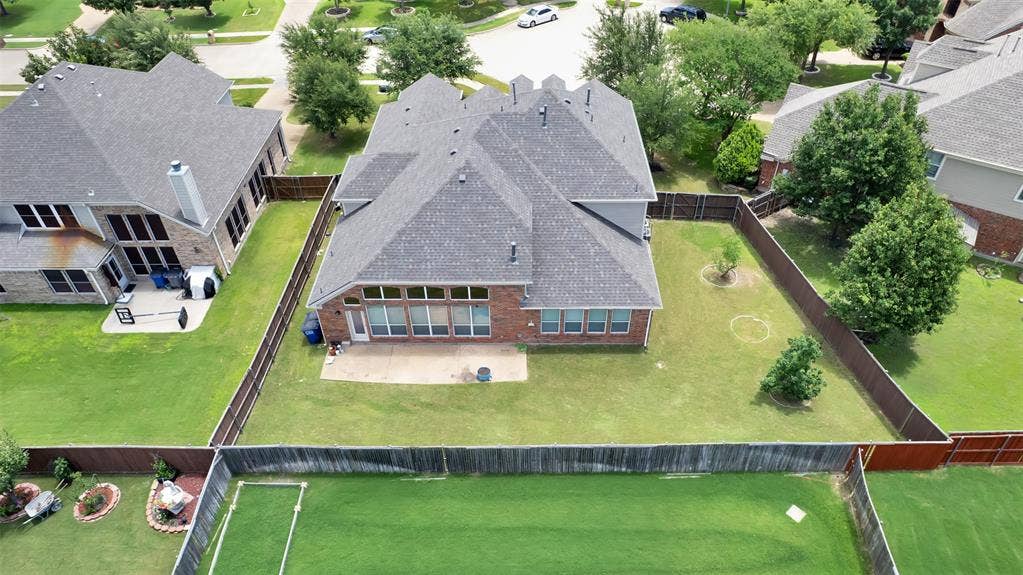 6811 Shady View Court, Sachse, TX 75048 Expansive rear yard with a paved patio, mature trees, and privacy fencing
