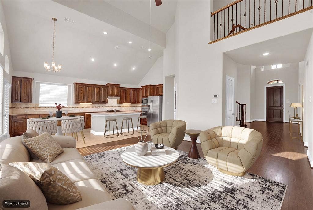 6811 Shady View Court, Sachse, TX 75048 Vaulted ceilings, recessed lighting, wood-finish flooring, island kitchen with integrated appliances, and a second-story interior balcony with wrought iron balusters