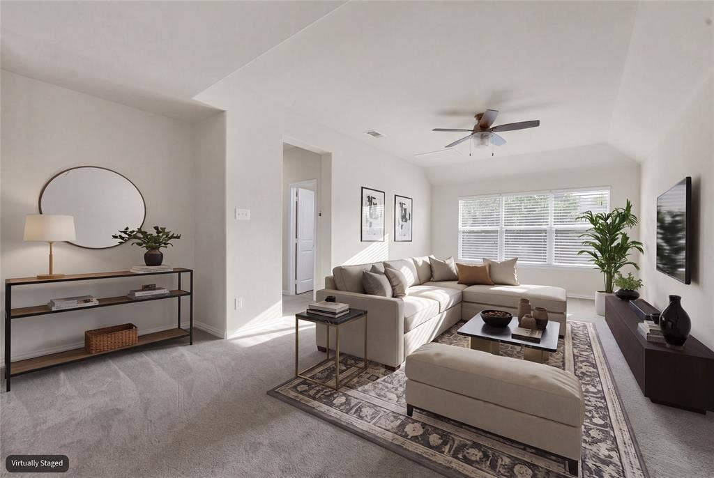 6811 Shady View Court, Sachse, TX 75048 Vaulted ceilings, a multi-pane window, and a ceiling fan are featured in this carpeted living area