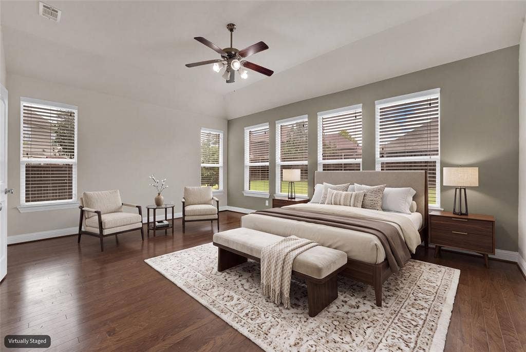 6811 Shady View Court, Sachse, TX 75048 Vaulted ceiling with ceiling fan, wood-finish flooring, multiple windows with blinds, and neutral wall tones