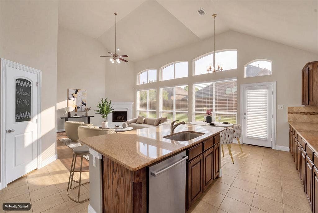6811 Shady View Court, Sachse, TX 75048 Vaulted ceiling, arched windows, kitchen island with integrated sink, stainless steel dishwasher, and tiled flooring
