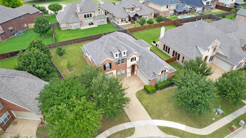 6811 Shady View Court, Sachse, TX 75048 Brick and stone facade, dormer windows, attached two-car garage, mature landscaping, and a concrete driveway