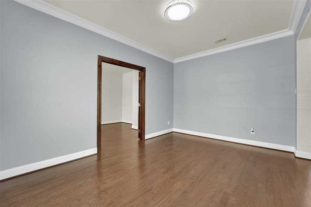 6811 Shady View Court, Sachse, TX 75048 Wood-finish flooring, crown molding, a recessed entryway, and a flush-mount ceiling light