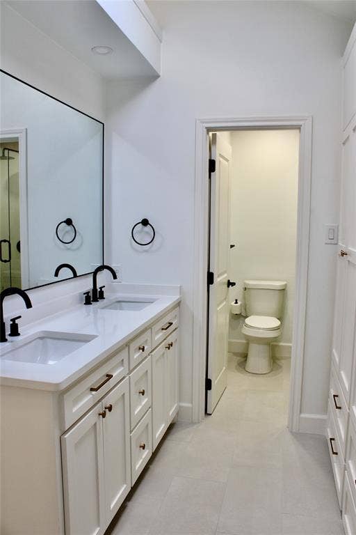 3706 Aries Drive, Garland, TX 75044 Double vanity with white cabinetry, matte black faucets, and bronze hardware