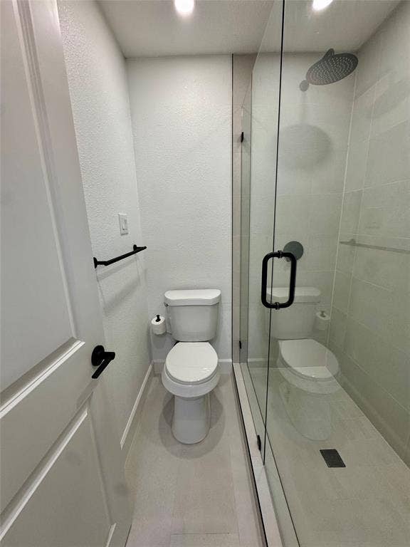 3706 Aries Drive, Garland, TX 75044 Modern bathroom featuring a frameless glass shower enclosure, rain shower head, and matte black fixtures