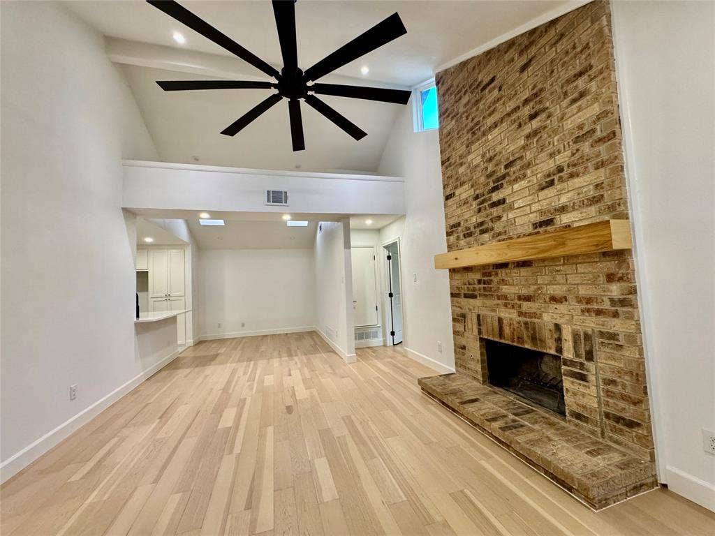 3706 Aries Drive, Garland, TX 75044 Vaulted ceiling, exposed brick fireplace with wood mantel, wood-finish flooring, large ceiling fan, and recessed lighting