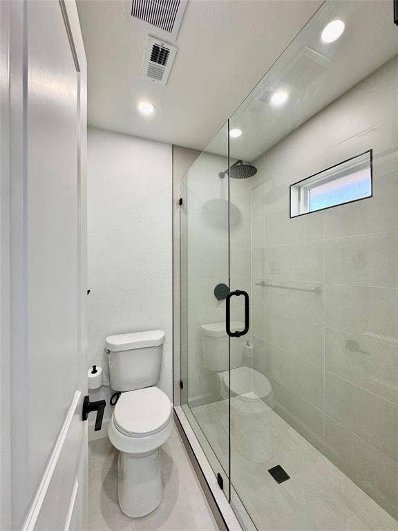 3706 Aries Drive, Garland, TX 75044 Glass-enclosed shower with a rainfall showerhead, tiled walls, and a linear drain