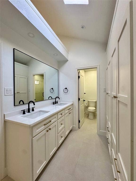 3706 Aries Drive, Garland, TX 75044 Dual vanity with white shaker cabinetry, white countertop, and black fixtures