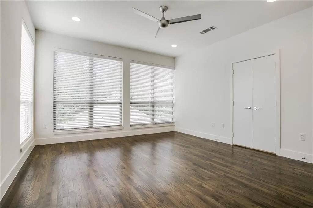 4303 Cole Avenue, #17, Dallas, TX 75205 Wood-finish flooring with white trim, multiple windows with blinds, built-in ceiling lighting, and a ceiling fan