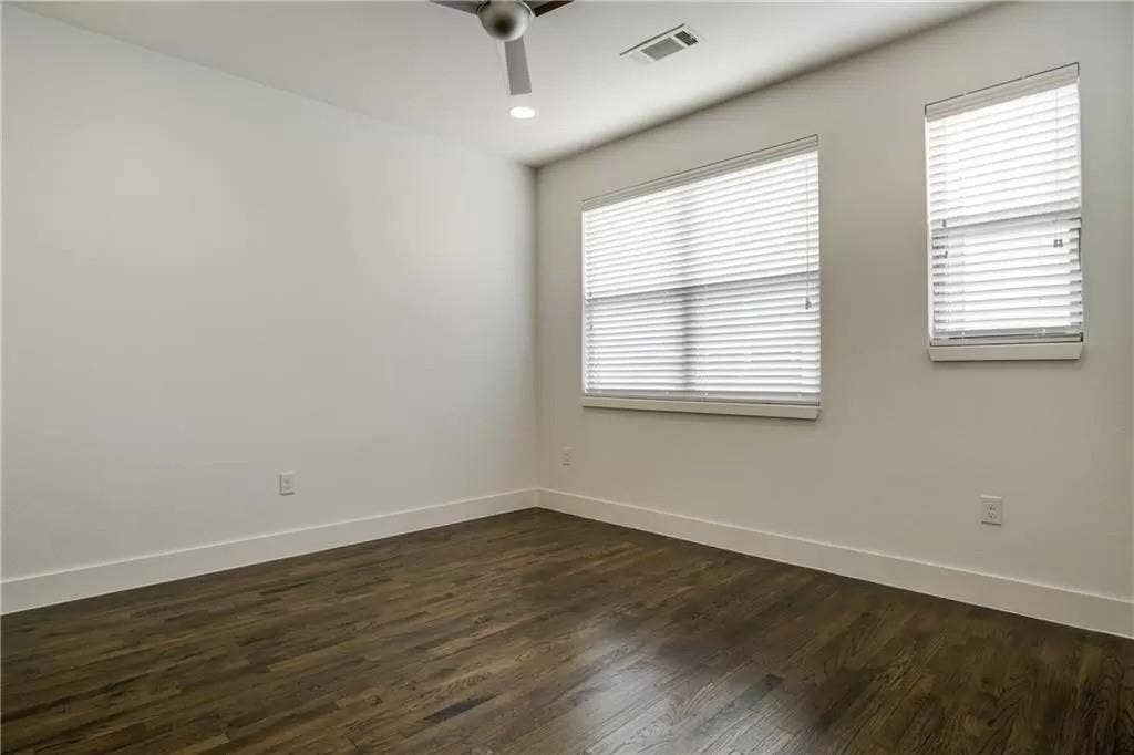 4303 Cole Avenue, #17, Dallas, TX 75205 Dark wood-finish flooring, white walls, two windows with blinds, a ceiling fan, and recessed lighting