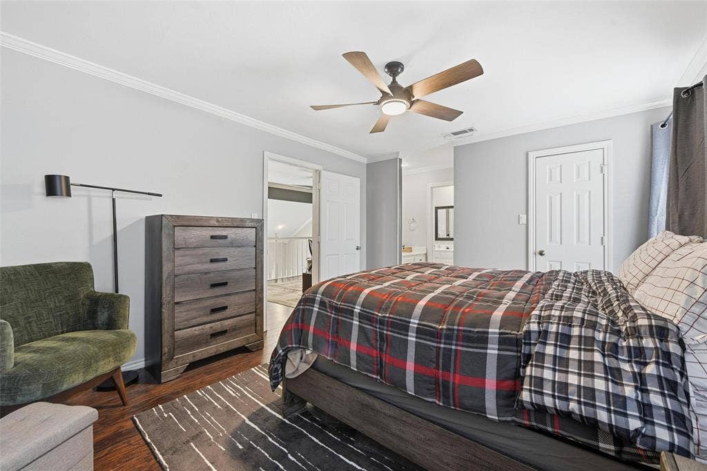 Wood-finish flooring, crown molding, and a ceiling fan with integrated lighting