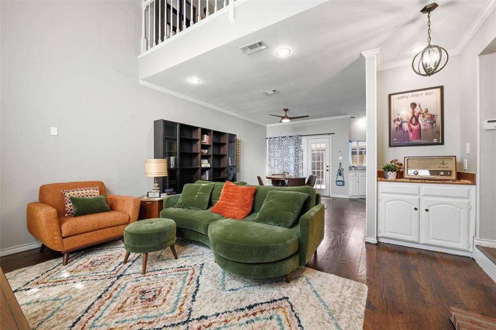 Vaulted ceilings, wood-finish flooring, built-in cabinetry, overhead lighting, and an open-concept design