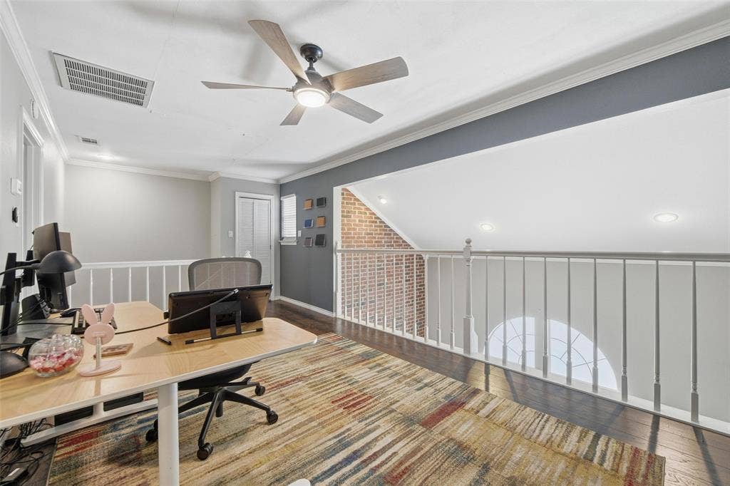 Loft space featuring dark wood-finish flooring, white railing, recessed lighting, and a ceiling fan with integrated light