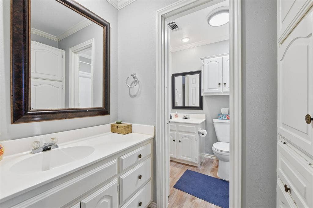 White vanity with an integrated sink, framed mirror, and chrome faucet