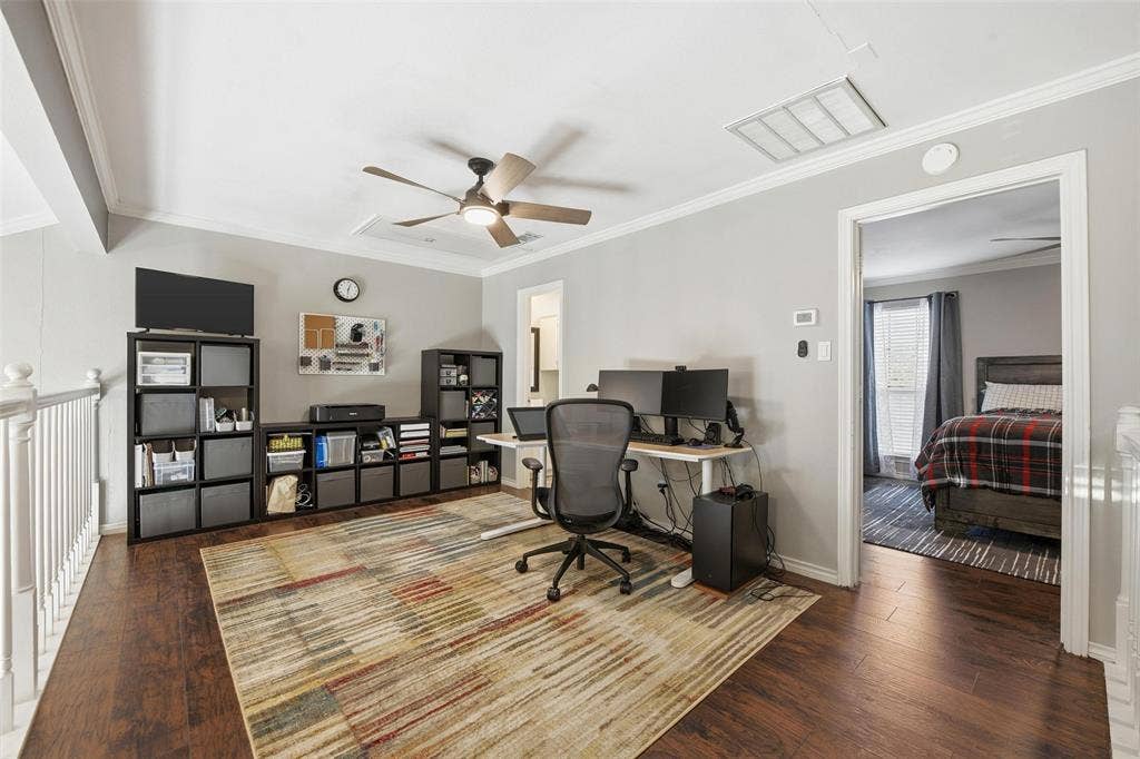 Wood-finish flooring throughout, complemented by light gray wall paint and white crown molding