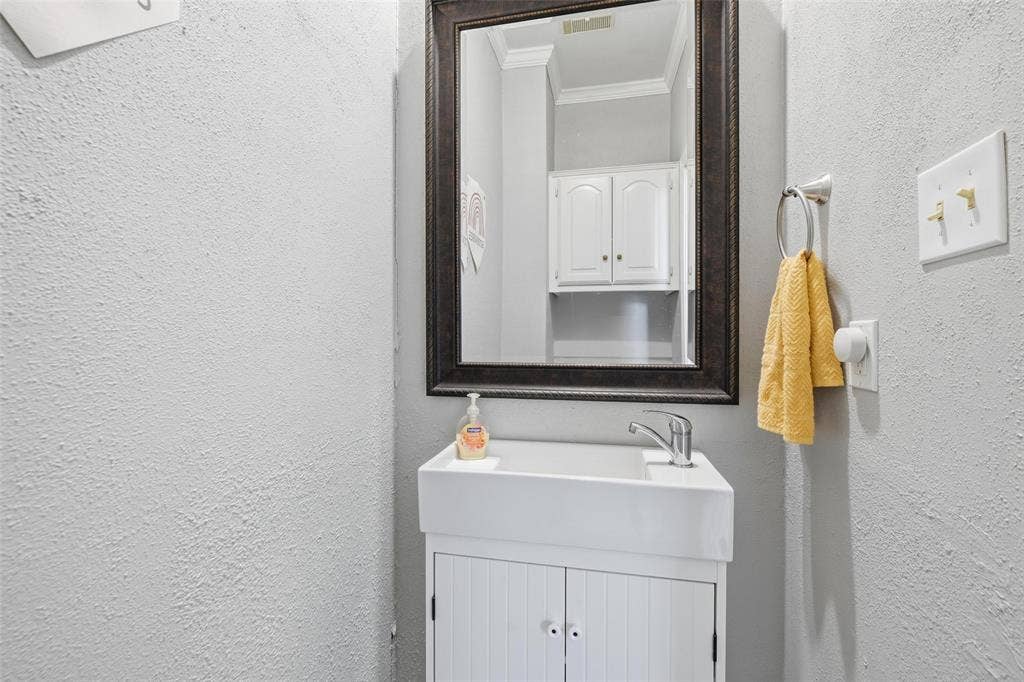 White vanity with beadboard door fronts, single basin sink, and chrome faucet