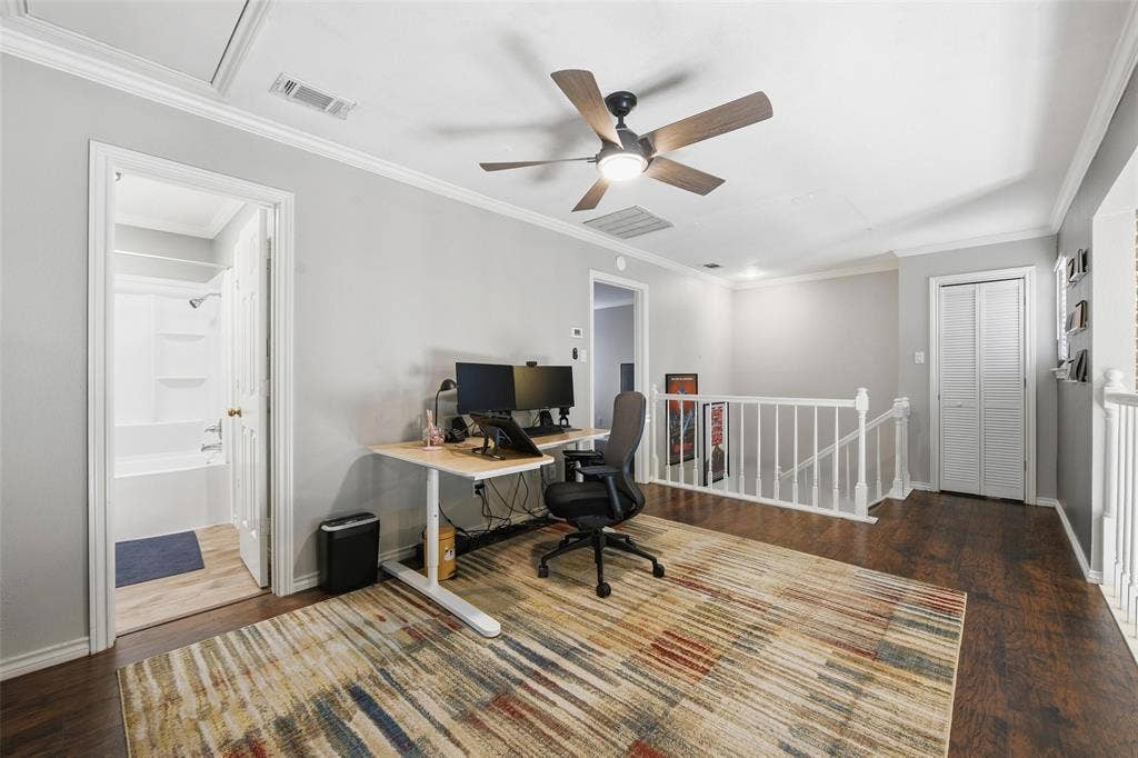Hardwood-finish flooring, crown molding, ceiling fan with integrated lighting, and a full bathroom with a white tub and shower combination