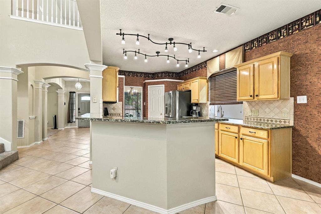 103 Deerpath Road, Hickory Creek, TX 75065 Kitchen featuring light wood cabinetry, tiled backsplash, and granite-look countertops