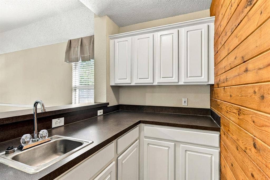 103 Deerpath Road, Hickory Creek, TX 75065 Kitchenette featuring white cabinetry, dark countertops, and a stainless steel sink