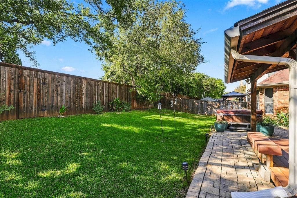 103 Deerpath Road, Hickory Creek, TX 75065 Expansive backyard featuring a lush lawn, wood privacy fence, and mature trees