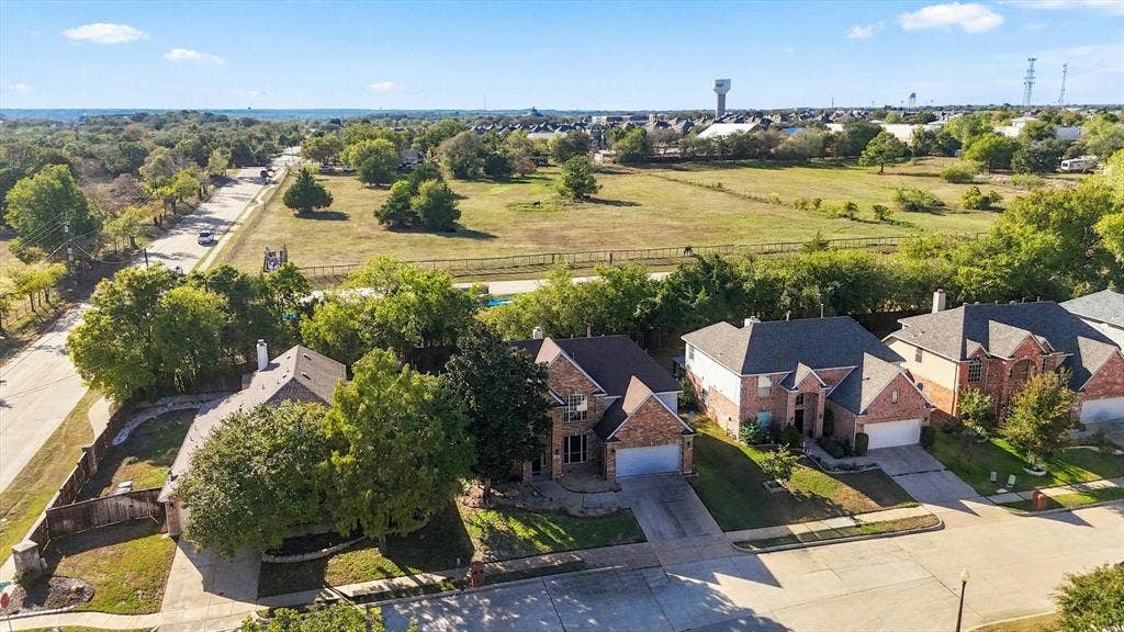 103 Deerpath Road, Hickory Creek, TX 75065 Aerial perspective showcasing a residential street, multiple properties with brick exteriors, and surrounding natural areas