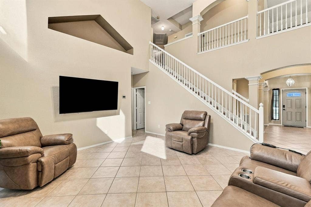 103 Deerpath Road, Hickory Creek, TX 75065 Two-story interior with tiled flooring, a prominent staircase with white railings, and an upper-level balcony overlooking the entry