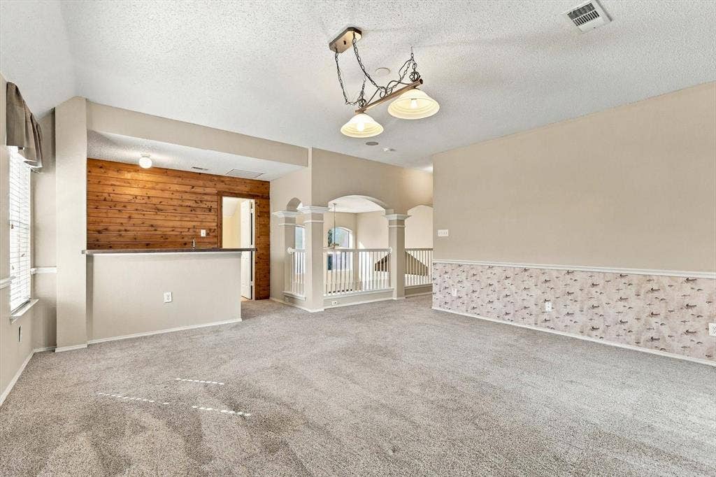 103 Deerpath Road, Hickory Creek, TX 75065 Carpeted living space with a built-in bar, wood paneling, and an overhead chandelier light fixture