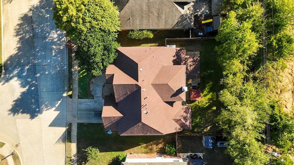 103 Deerpath Road, Hickory Creek, TX 75065 Residential property featuring a brown shingle roof, concrete driveway, and established trees