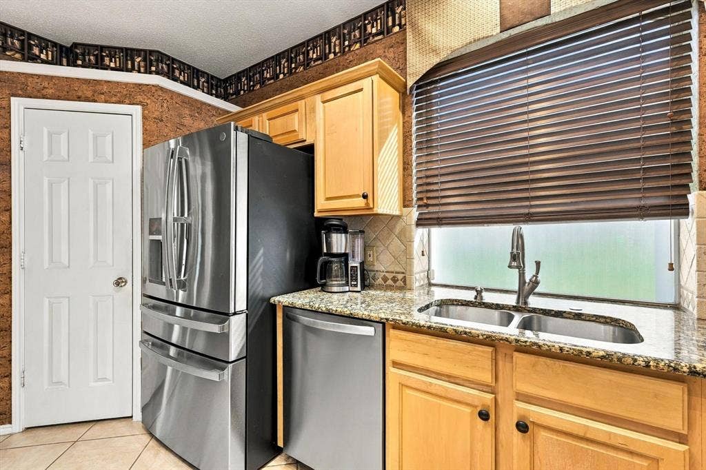 103 Deerpath Road, Hickory Creek, TX 75065 Stainless steel appliances, wood-finish cabinetry, granite countertops, double basin sink, and window blinds