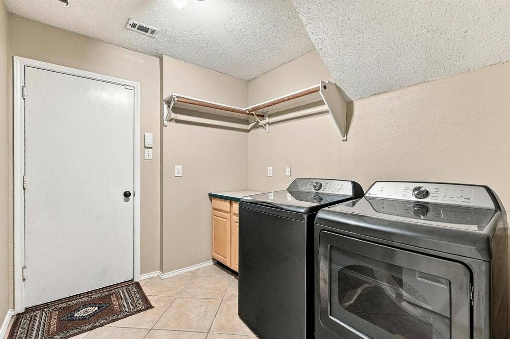 103 Deerpath Road, Hickory Creek, TX 75065 Laundry area featuring tile flooring, built-in cabinetry with a countertop, and a wall-mounted shelving unit