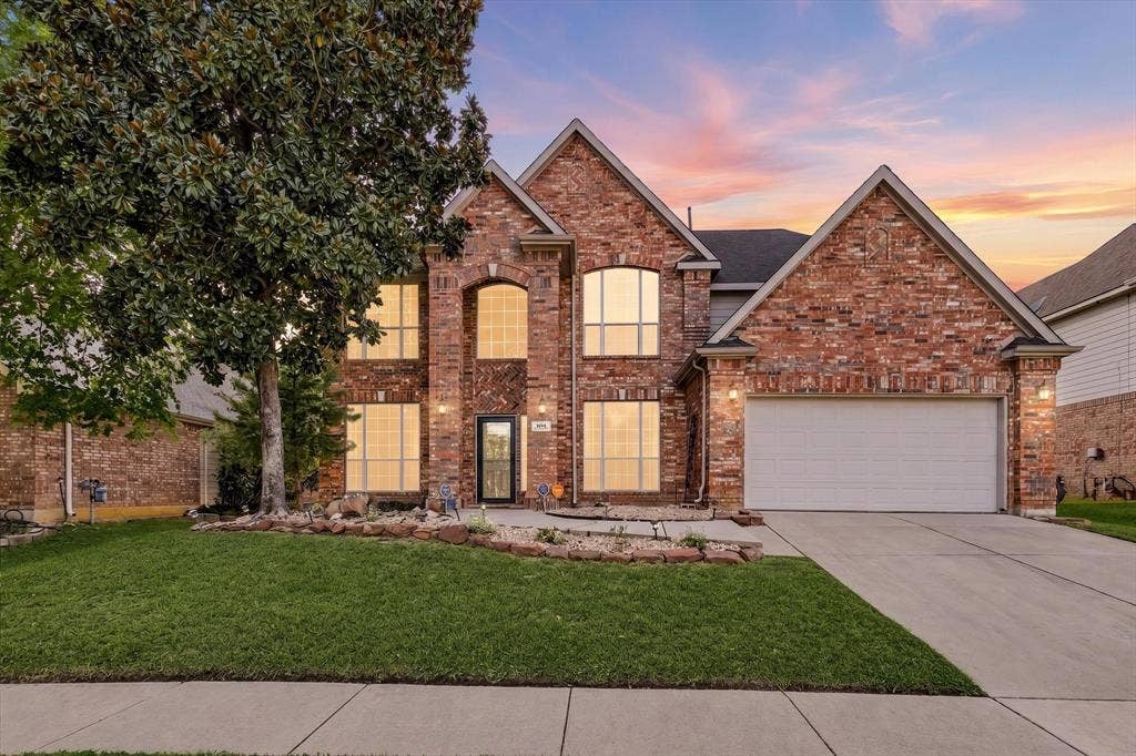 103 Deerpath Road, Hickory Creek, TX 75065 Brick exterior with multiple gables, arched entry, mature front yard tree, concrete driveway, and attached garage