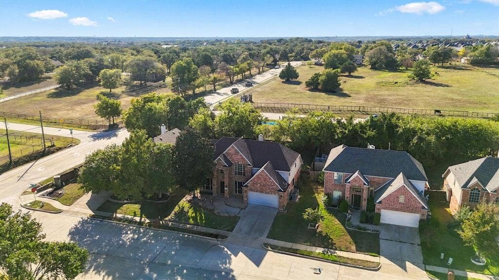 103 Deerpath Road, Hickory Creek, TX 75065 Two-story residences featuring brick and siding exteriors, attached garages, and mature landscaping, situated on a residential street