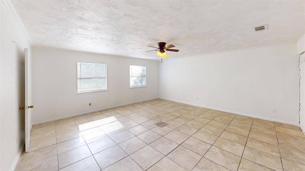 1710 Meridian Way, Garland, TX 75040 Spacious room featuring tile flooring, a ceiling fan with integrated lighting, and multiple windows