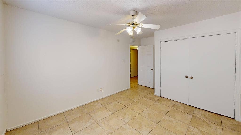 1710 Meridian Way, Garland, TX 75040 Ceramic tile flooring, bi-fold closet doors, ceiling fan with light fixture, and a paneled interior door