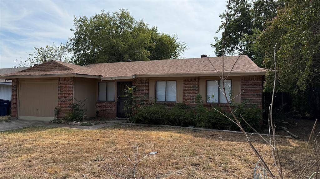 1710 Meridian Way, Garland, TX 75040 Brick exterior with a single-car garage and a pitched roof