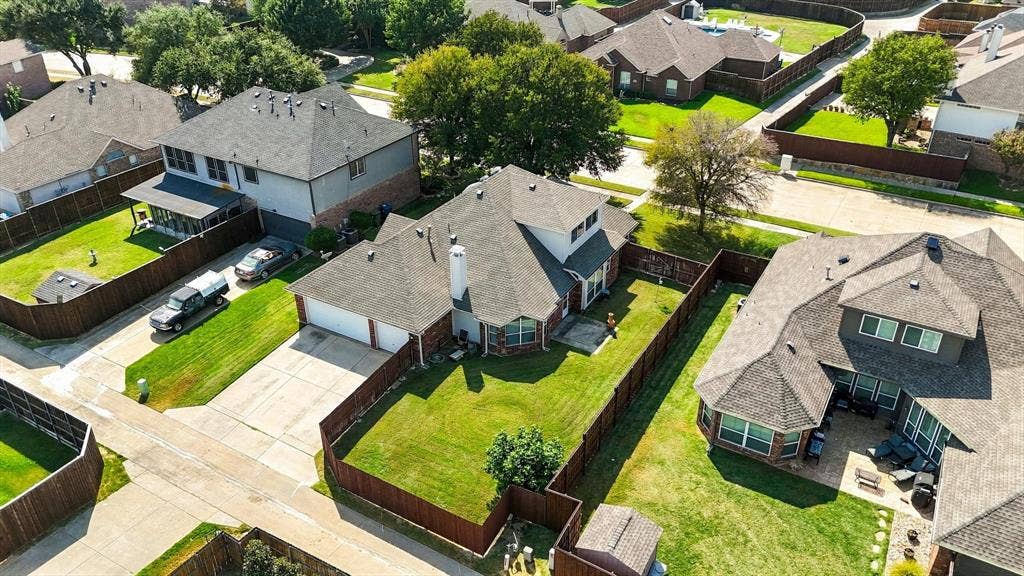 Brick exterior, attached garage, fenced backyard, mature landscaping, and an outdoor patio area