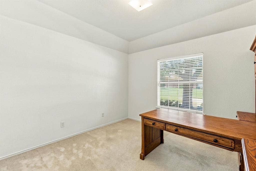 Recessed ceiling with an integrated light fixture, window with horizontal blinds, and carpeting