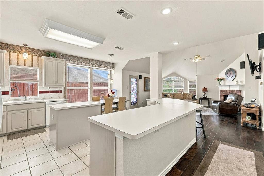 Kitchen with white cabinetry, tile flooring, and a breakfast bar