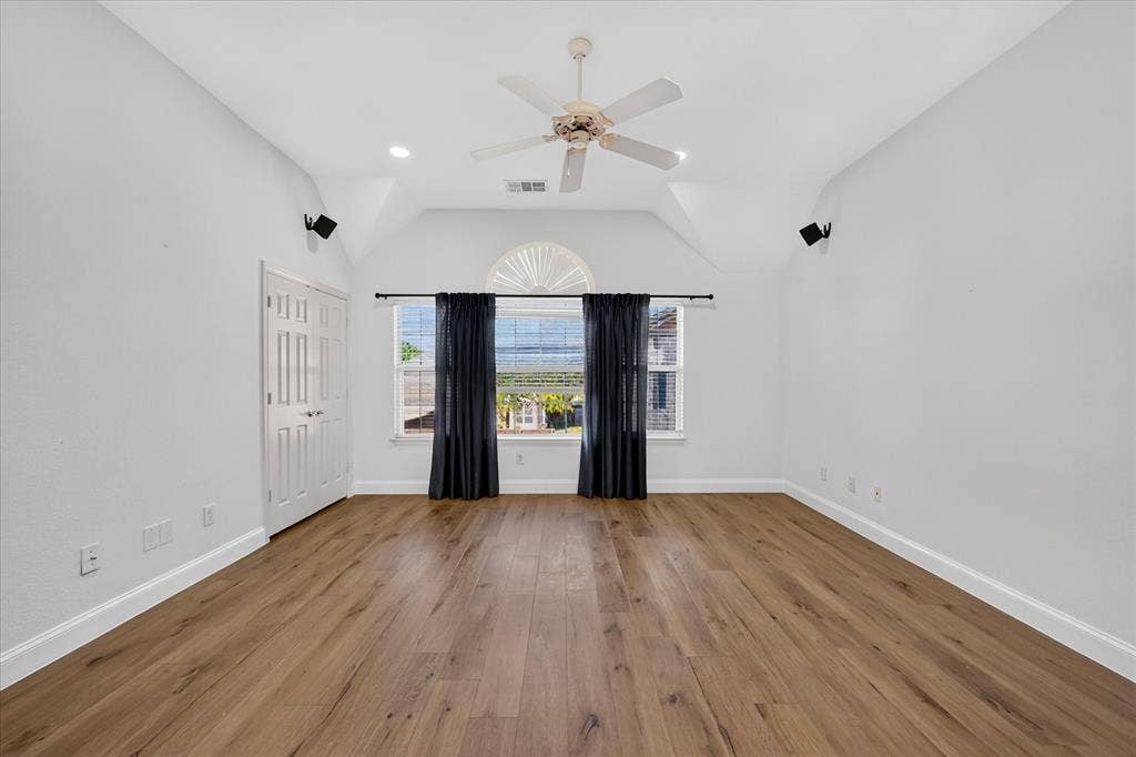 10601 Whispering Pines Drive, Frisco, TX 75033 Vaulted ceiling with a ceiling fan, recessed lighting, wood-finish flooring, and a window with an arched transom